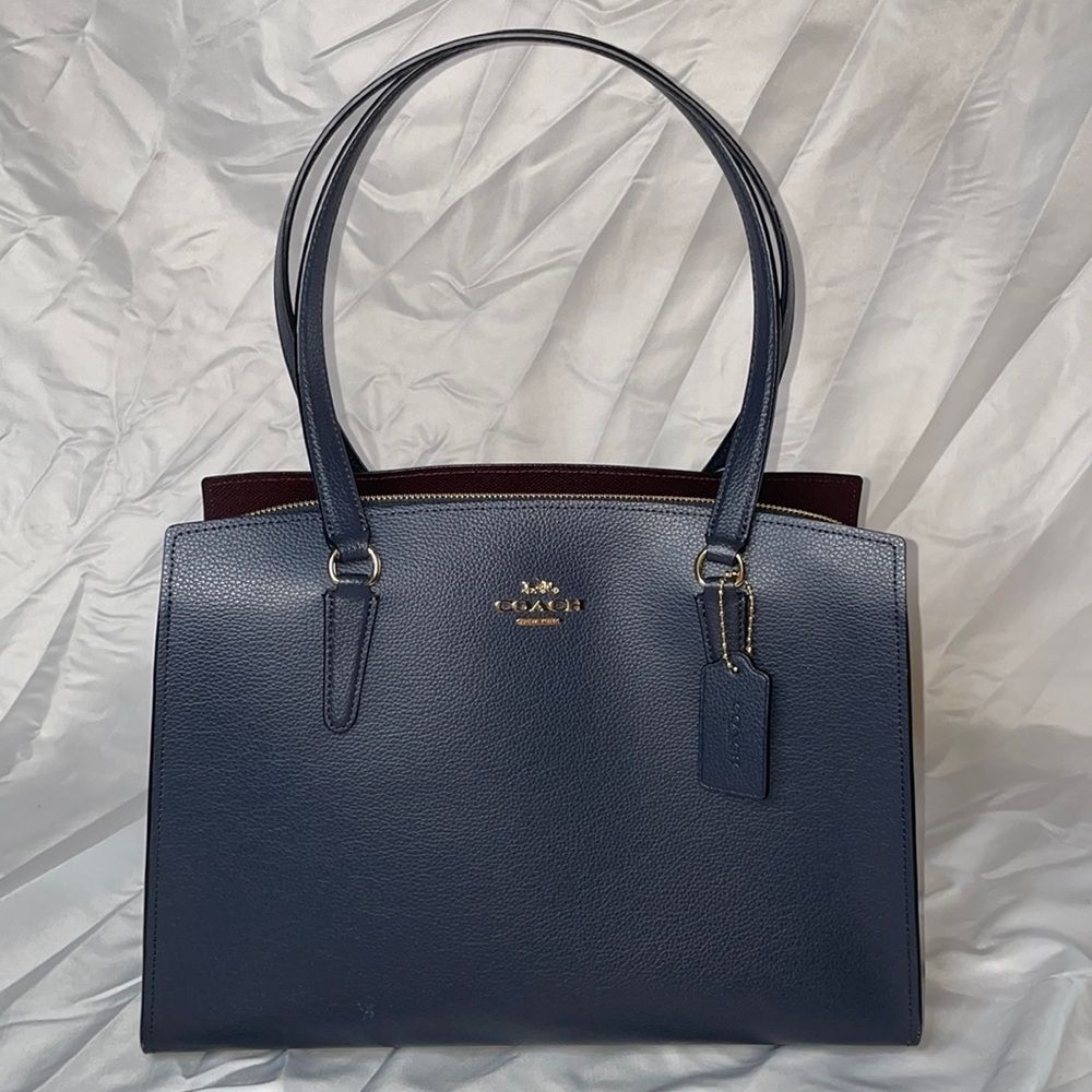 COACH carryall shoulder tote with middle zip compartment and crossbody strap.